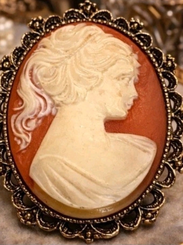 Elegant Cream Cameo Brooch On Warm Brown Background